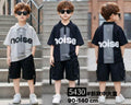 Three children wearing matching outfits with 'noise' branding on a staircase.