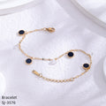 Gold bracelet with black stones on a white towel