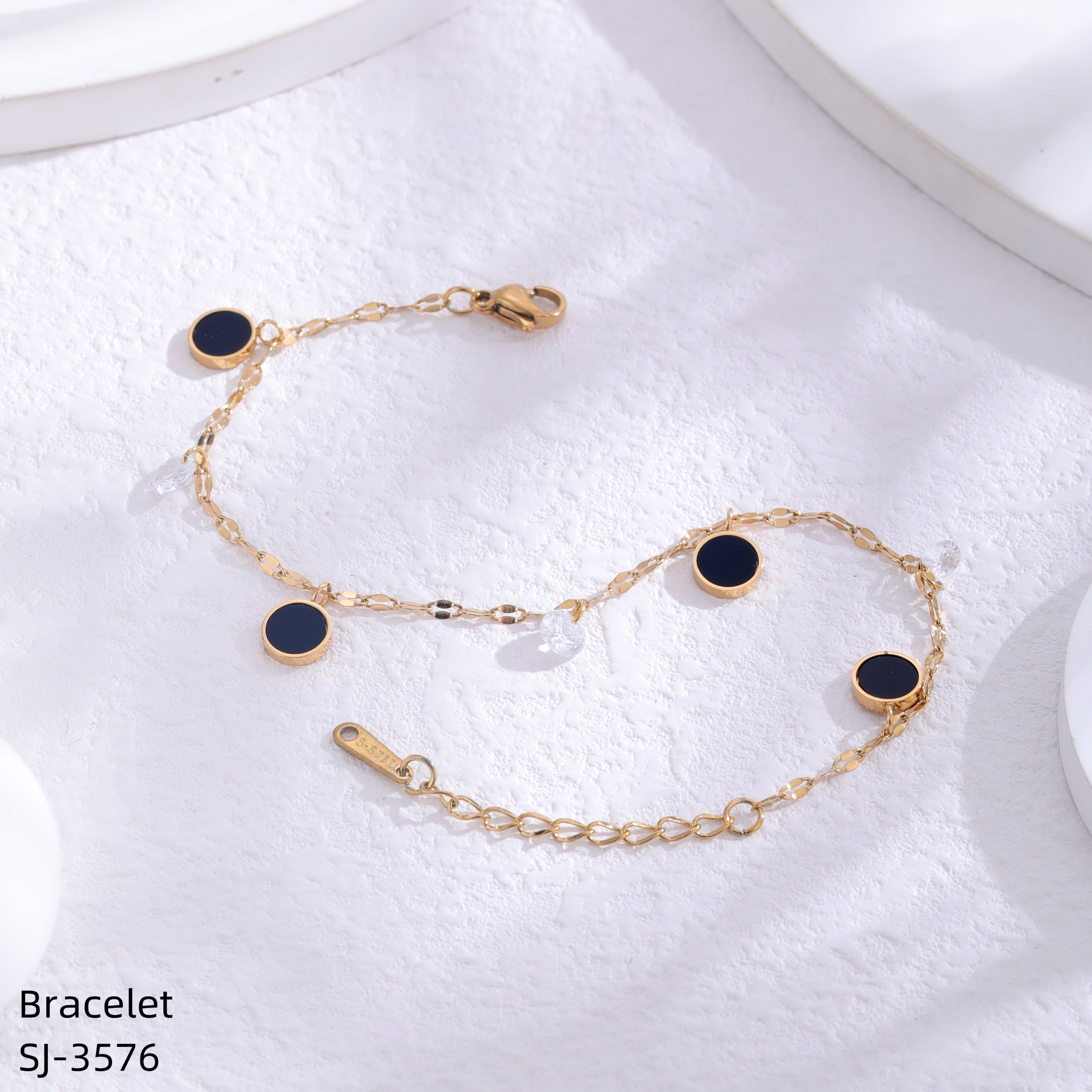 Gold bracelet with black stones on a white towel