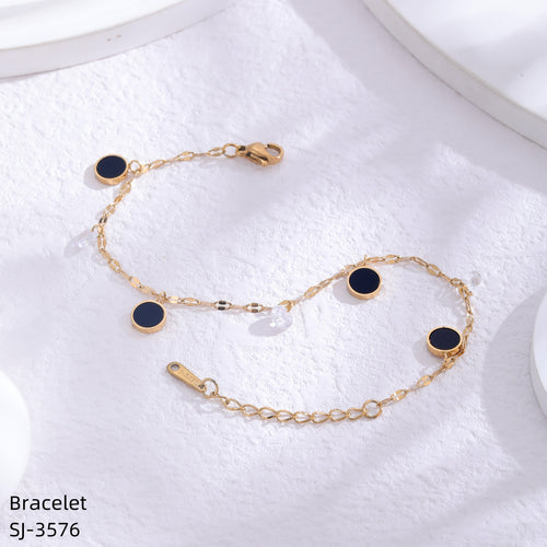Gold bracelet with black stones on a white towel