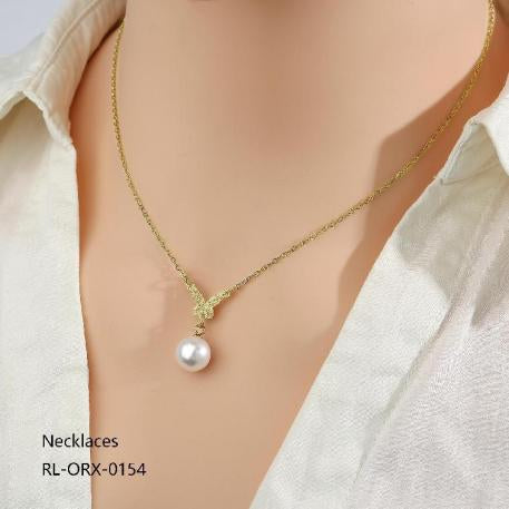 Gold necklace with a pearl pendant on a mannequin wearing a light-colored shirt.