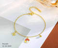 Gold bracelet with charms on a white and brown paper background