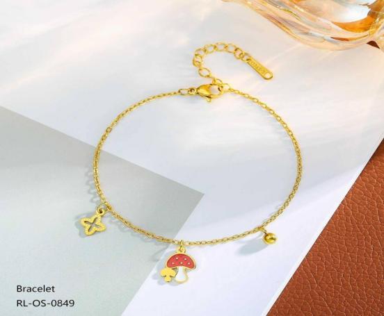 Gold bracelet with charms on a white and brown paper background