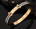Gold bracelet with diamond accents on a dark background