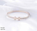 Rose gold bangle with diamond accents on a white background