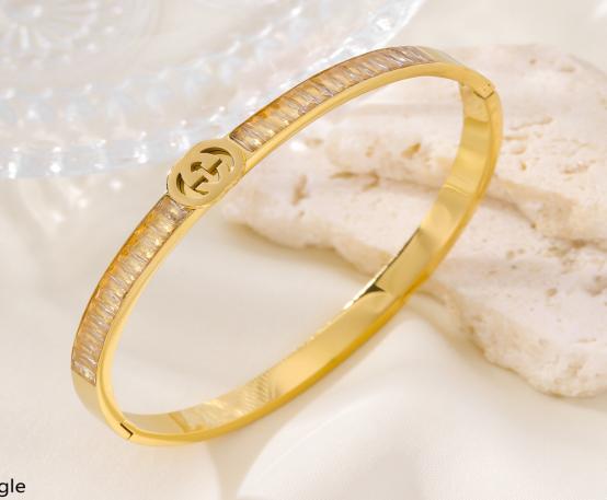 Gold bracelet with diamond like accent on a light background