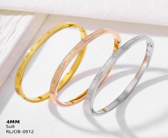 Three gold bangles of different colors on a white background