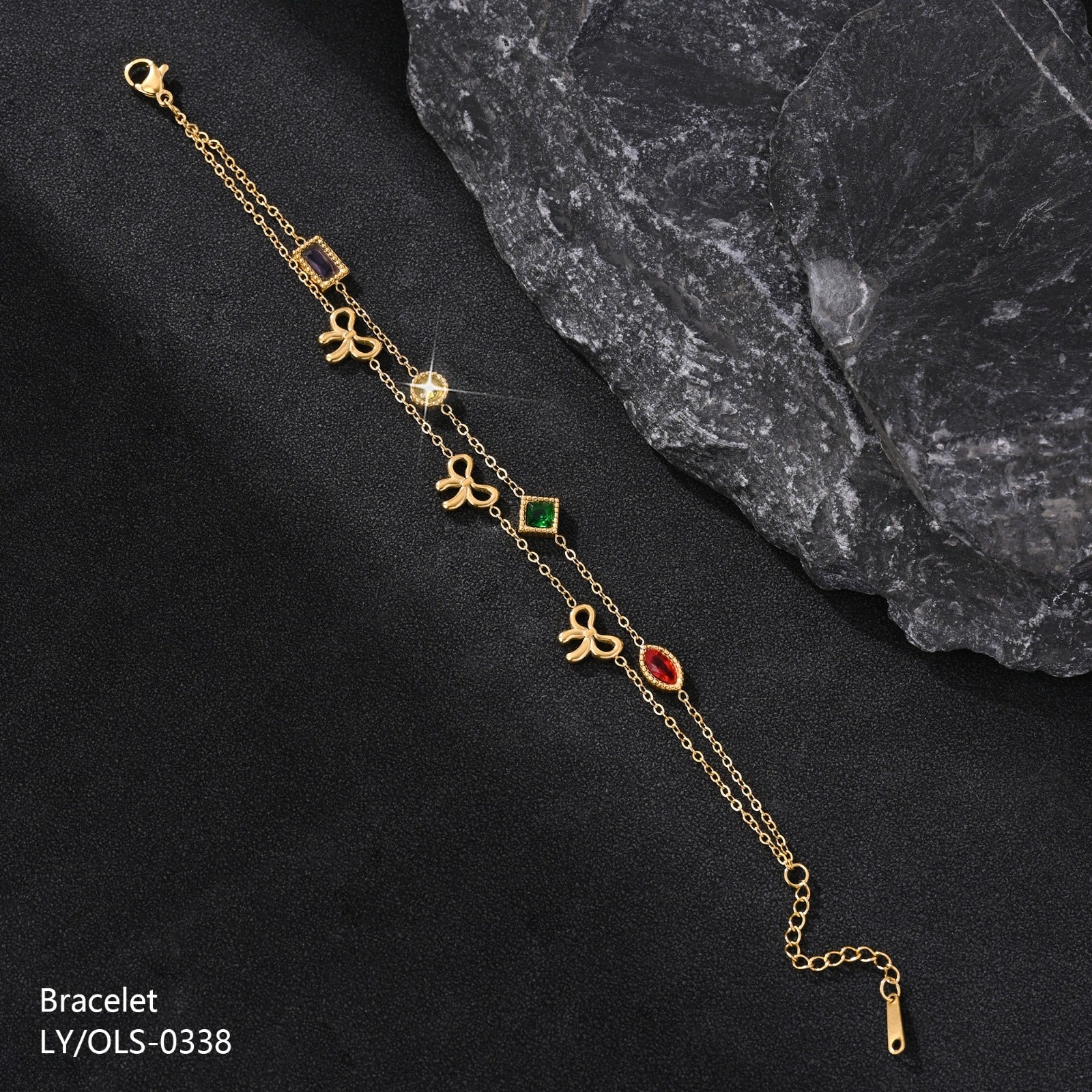 Gold bracelet with decorative charms on a dark surface