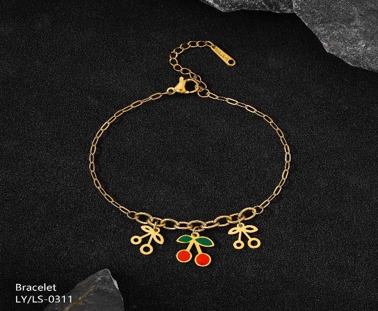 Gold bracelet with colorful charms on a dark background