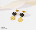 Gold and black floral earrings on a white background