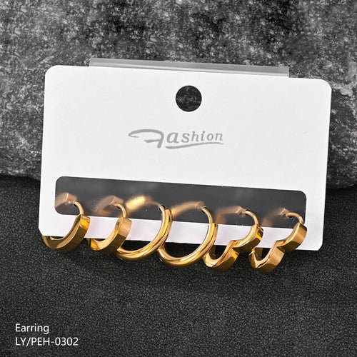 Gold earrings on a white card with 'Fashion' branding against a dark textured background