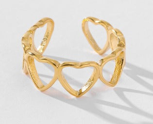 Gold heart-shaped bracelet on a light gray background