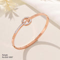 Rose gold bangle with a diamond accent on a light background