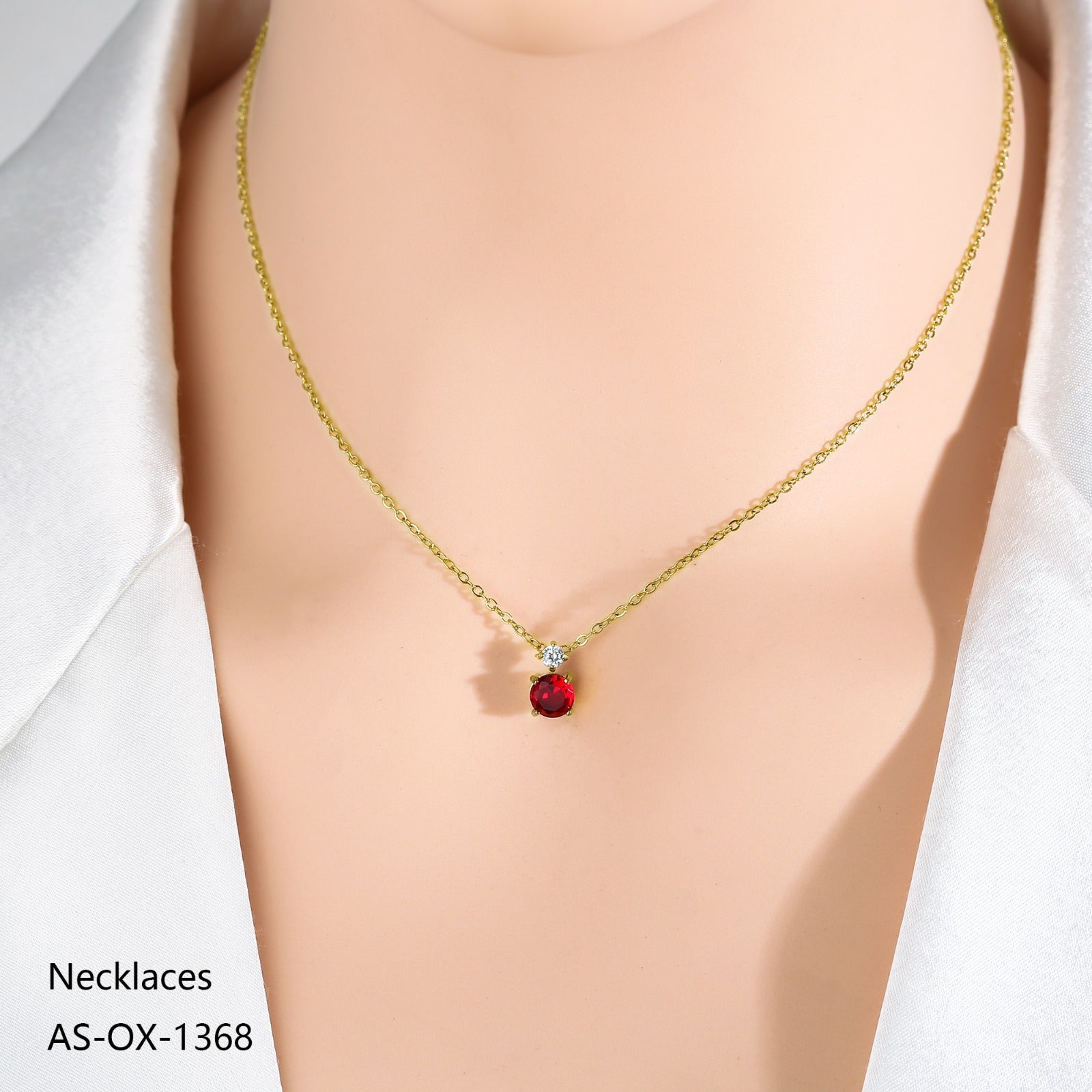 Gold necklace with a red pendant on a mannequin