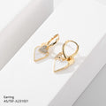 Gold heart-shaped earrings on a light gray background